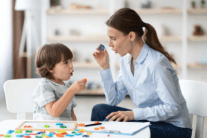 Female speech therapist curing child's problems and impediments.