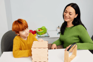 Parent helping child with level 1 autism learn social skills through structured play activities